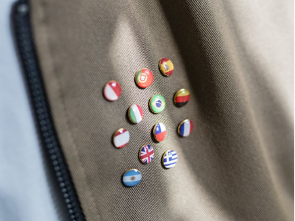 Badges met vlaggen van over heel de wereld vastgemaakt op een jas.