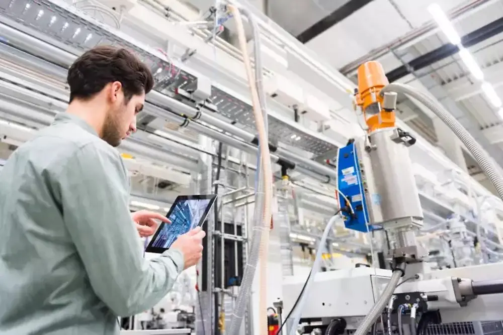 Werknemers bedienen machines in een industriële fabriek.