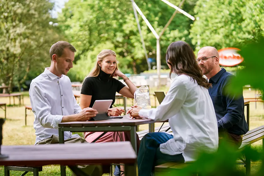 Vier collega's die buiten samenzitten.