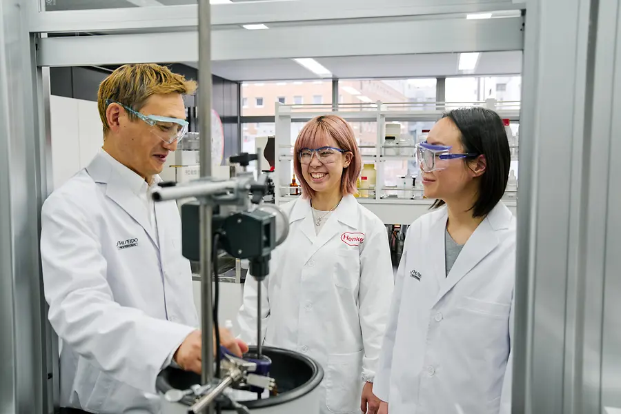 Drie mensen die in een laboratorium werken.